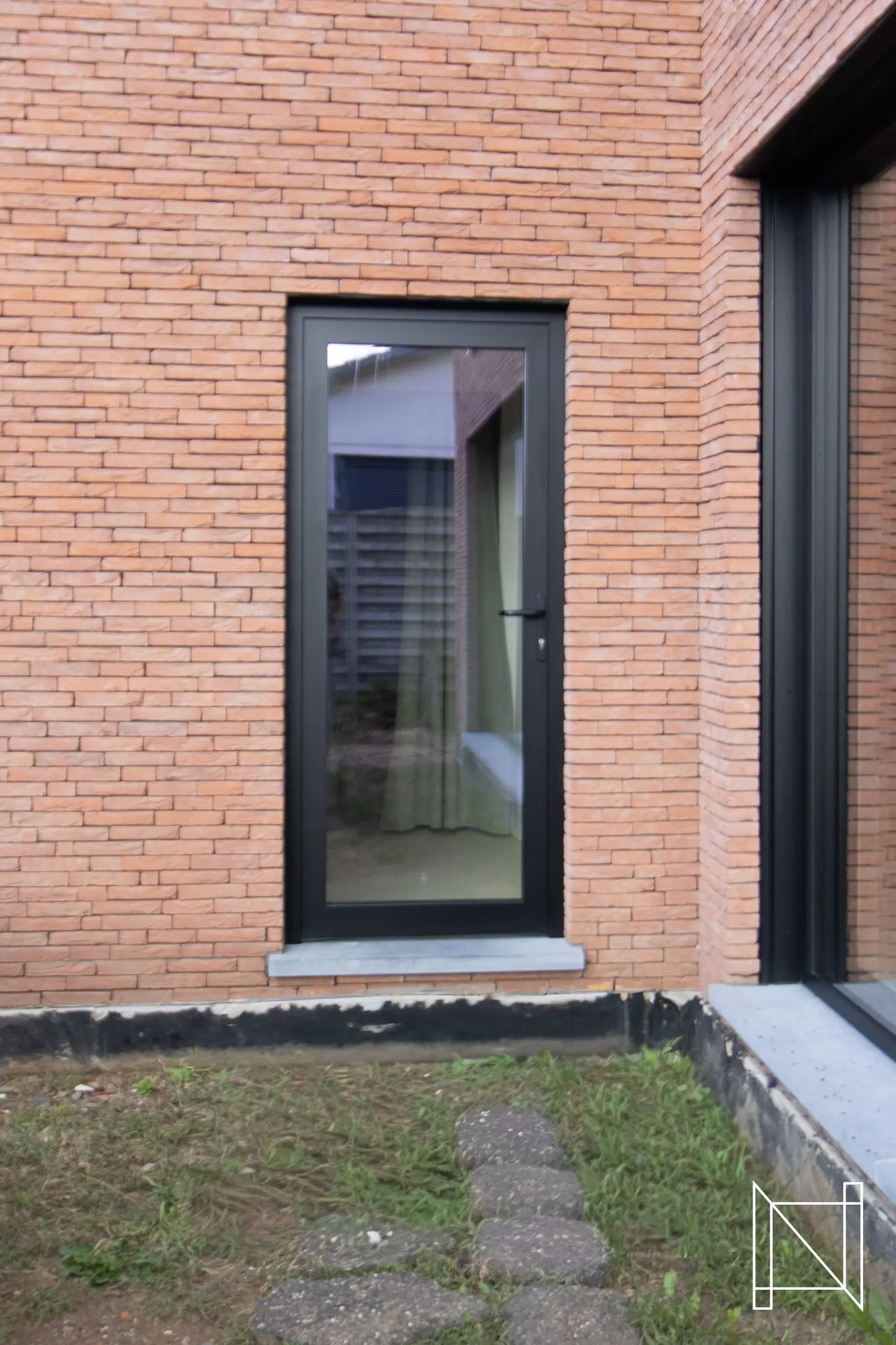 Smal aluminium raam in een bakstenen gevel